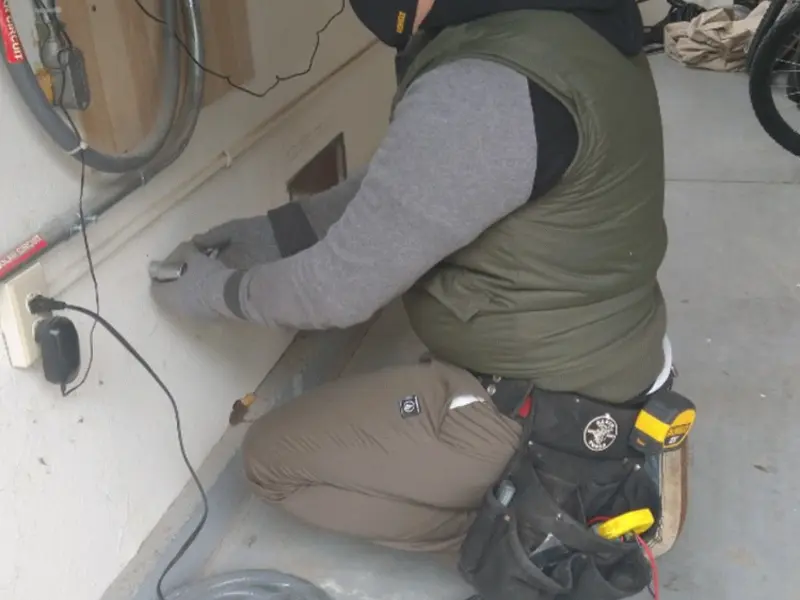 Electrician performing outlet wiring in a Woodlake garage